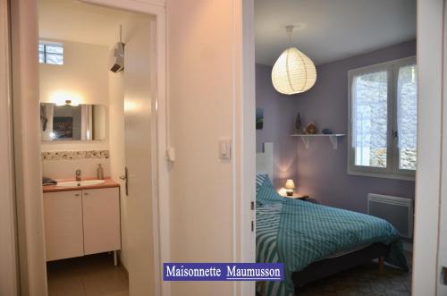 a bedroom with a bed and a desk and a window at Villa des 4 saisons in Saint-Trojan-les-Bains