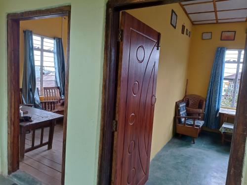 K Swu Homestay في Kohīma: غرفة مع باب وطاولة في غرفة