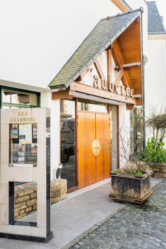 a building with a wooden door in front of it at Logis L'Auberge - Maison Glenn Anna in Sainte Anne d'Auray 