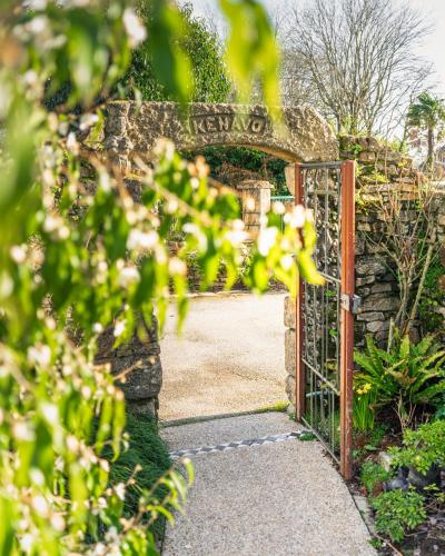 an entrance to a garden with an open gate at Logis L'Auberge - Maison Glenn Anna in Sainte Anne d'Auray 