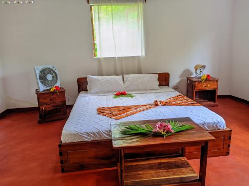 a bedroom with a bed and a table with flowers on it at Villa Soa in Ile aux Nattes