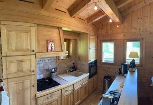a kitchen with wooden cabinets and a sink and a stove at Chalet familial sur les pistes in Megève