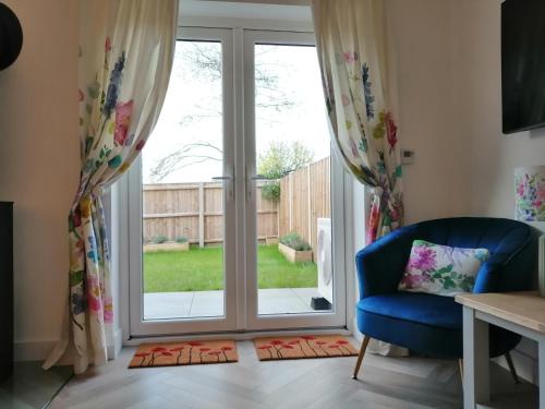 a living room with a sliding glass door at Bluebells, Little Snoring in Fakenham