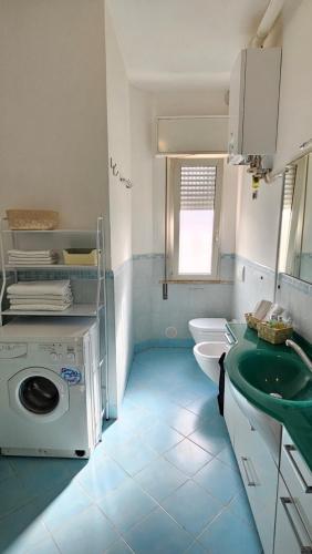 een badkamer met wastafel en wasmachine bij Happy House - Marina Centro in Rimini