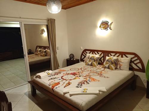 a bedroom with a large bed with a mirror at Ô Bleu Azur in Antsatrakolo