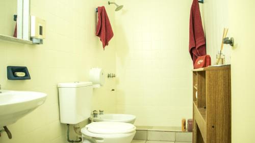 a white bathroom with a toilet and a sink at Habitación en Palermo in Buenos Aires