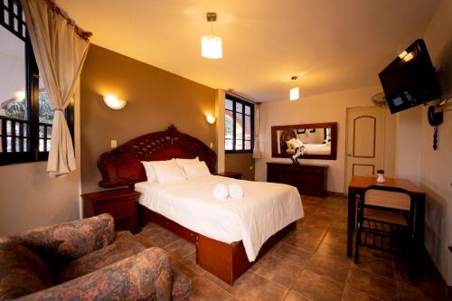 a bedroom with a large bed and a chair at Hotel Fundo San Rafael in Nazca