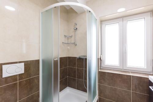 een douche met een glazen deur in de badkamer bij Apartmani Šimi - The Wave in Crikvenica