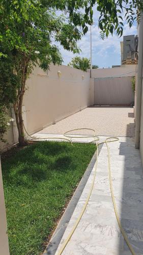 a hose is on the grass in a yard at Villa Sérénité, Yasmine Hammamet in Hammamet