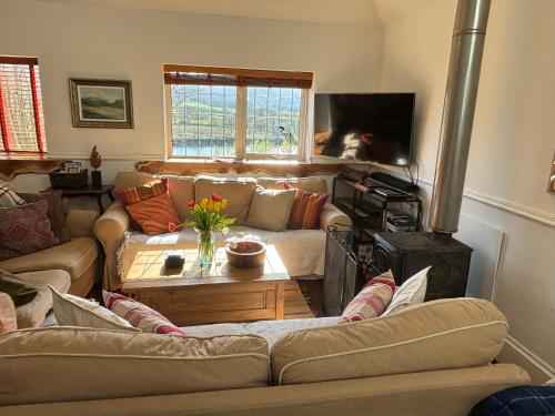 a living room with two couches and a fireplace at North Lodge Kilmun in Kilmun