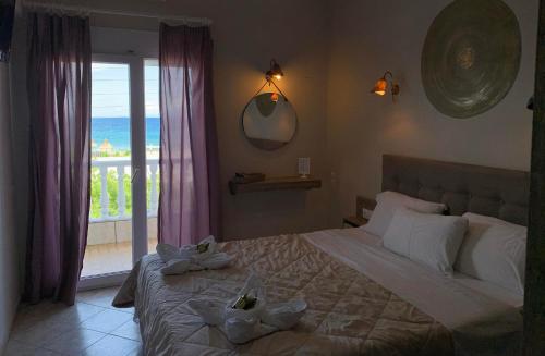 a bedroom with a bed with two towels on it at Dionisos Hotel in Nei Poroi