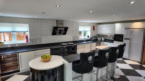 a large kitchen with black and white checkered floor at Stratford-upon-Avon 4BR Family Mansion on 1 acre with Pool, Gym & BBQ! in Henley in Arden