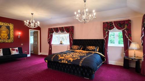 a bedroom with a bed and a chandelier at Stratford-upon-Avon 4BR Family Mansion on 1 acre with Pool, Gym & BBQ! in Henley in Arden