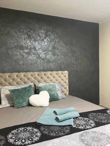 a bedroom with a large bed with green pillows at Tea i Una in Arandjelovac