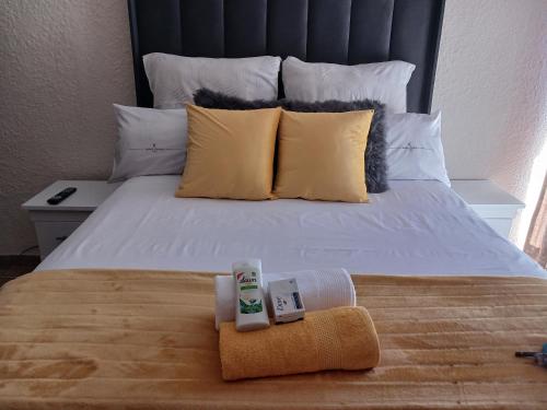 ein Bett mit zwei kostenfreien Handtüchern darüber in der Unterkunft GOLDEN GLORY INN in Roodepoort