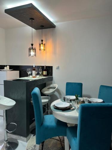 a dining room with a table and blue chairs at Tea i Una in Arandjelovac