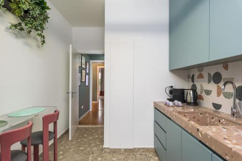 a kitchen with blue cabinets and a counter with stools at Perla's 2-BR Apt in Mar Mikhael in Beirut