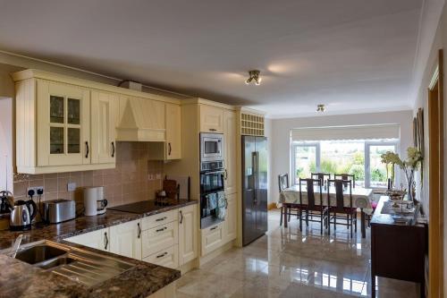 a kitchen with white cabinets and a dining room at Lake View House in Recess