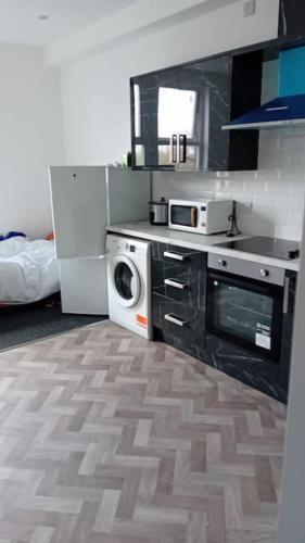 uma cozinha com uma máquina de lavar roupa e um micro-ondas em Studio Flat 2 Nelson Town Centre em Nelson