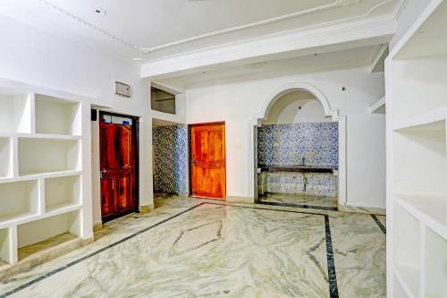 um quarto com duas portas vermelhas e um piso de mármore em Super OYO Flagship Namaskar Cozzy Cottage em Bhubaneshwar