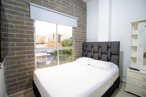 um quarto com uma cama grande e uma janela em Laureles Estadio 2 Alc Apartamento completo 501 em Medellín
