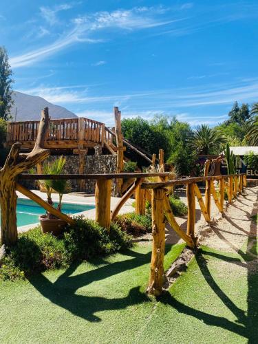 un banco de madera sentado junto a una piscina en Cabañas Rusticas Olimpus del Elqui en Vicuña