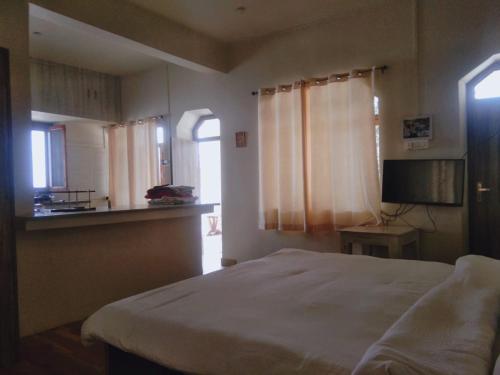 a bedroom with a bed and a small kitchen at BN Resort in Gangolihāt