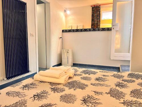 Un baño con una cama con una toalla en el suelo. en Le 3 case di Mia, en Marciana Marina