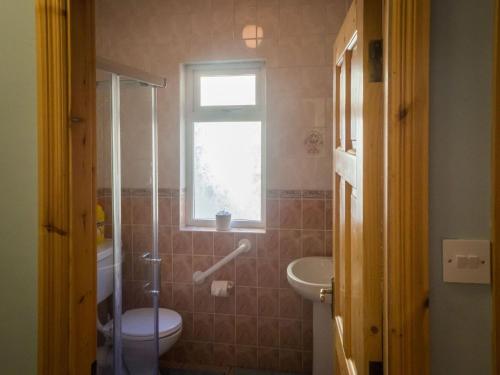 a bathroom with a toilet and a sink and a window at Lough Fee Renvyle in Renvyle