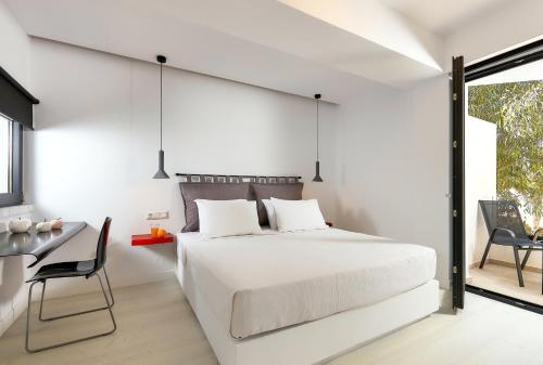 a bedroom with a white bed and a desk at MichELe Luxury apartments by Smaris Collection in Malia