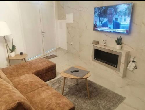 a living room with a couch and a flat screen tv at Cava do Viriato Apartamento in Viseu