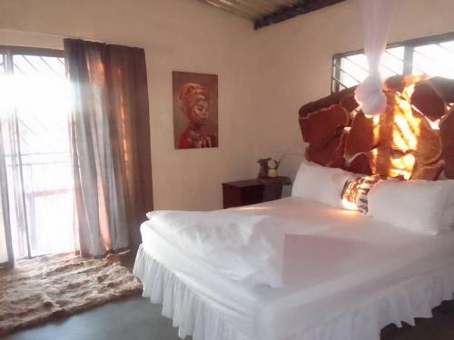 1 dormitorio con cama grande y ventana grande en Etoko Farm Camp en Uis
