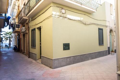 an alley in a city with a yellow building at La Marina - Casa Assuntina in Letojanni