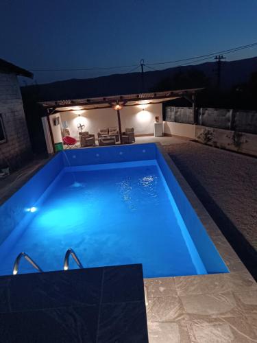 a swimming pool lit up at night at Apartmani Calimero in Mostar