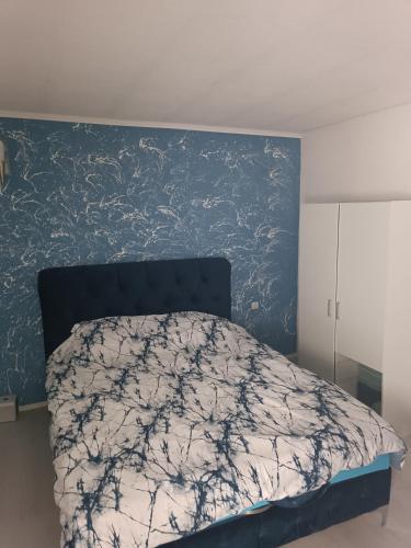 1 dormitorio con 1 cama con pared azul en Apartmani Calimero, en Mostar