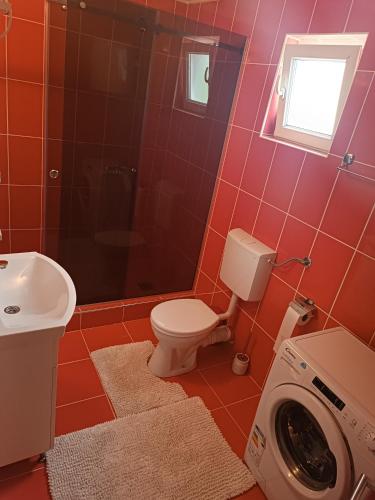 a bathroom with a toilet and a washing machine at Apartmani Calimero in Mostar