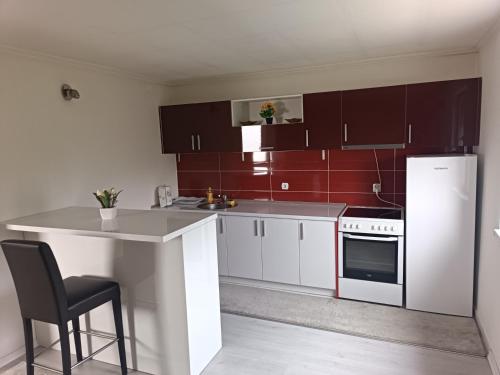 a kitchen with white cabinets and a white refrigerator at Apartmani Calimero in Mostar