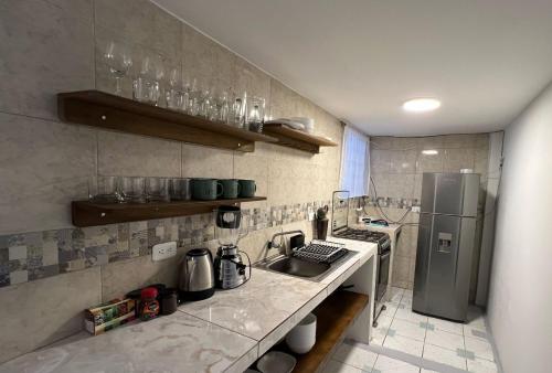 uma cozinha com um lavatório e um frigorífico em Town Apartment with terrace 4 bedrooms 3 baths em Baños