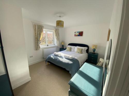 a small bedroom with a bed and a window at Bluebells, Little Snoring in Fakenham