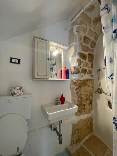 a bathroom with a sink and a stone wall at Casa Mimmo in Ostuni