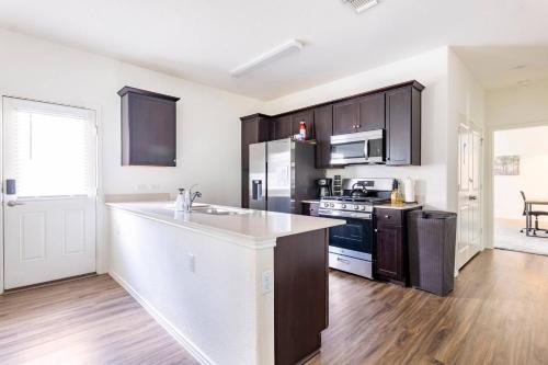 a kitchen with black cabinets and a white counter top at Contemporary Austin Home Near Downtown & Airport in Austin