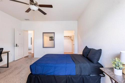 a bedroom with a blue bed and a ceiling fan at Contemporary Austin Home Near Downtown & Airport in Austin
