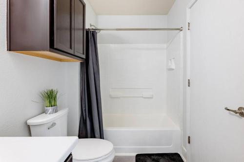 a bathroom with a white toilet and a shower at Serenity Home Near Downtown & Airport in Austin