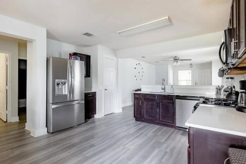 a kitchen with a stainless steel refrigerator and wooden floors at Serenity Home Near Downtown & Airport in Austin