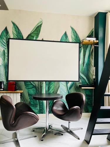 une table et deux chaises devant un écran dans l'établissement Studio Mezzanine, à Rouen