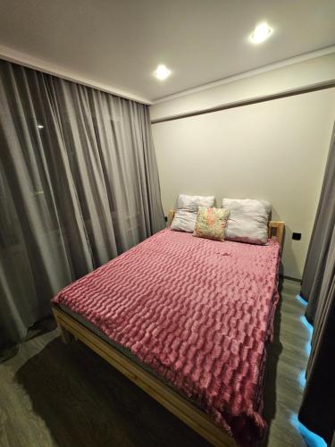 - une chambre avec un lit et une couette rouge dans l'établissement Квартира, à Balkhach