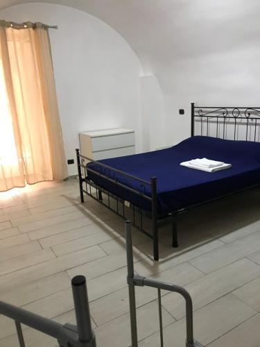 um quarto com uma cama com um cobertor azul em Casa poli em Portici