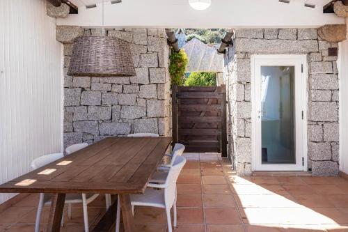 a dining room with a wooden table and chairs at BGItalianVacation - Ville Li Conchi in Castiadas