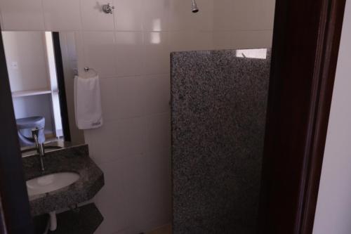 ein Bad mit einem Waschbecken und einer Dusche in der Unterkunft Pousada Apear in Andradas