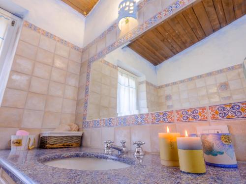 a bathroom with a sink with two candles and a mirror at Sardinia Family Villas Villa Lucrezia in Baja Sardinia